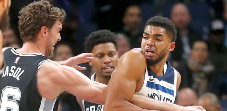 Karl-Anthony Towns, de Minnesota, lucha por la posesión del balón con Pau Gasol, de los Spurs, en acción del partido de anoche.