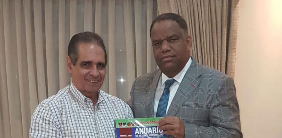 Héctor J. Cruz hace entrega del Anuario de Béisbol al Ministro de Deportes Danilo Díaz.