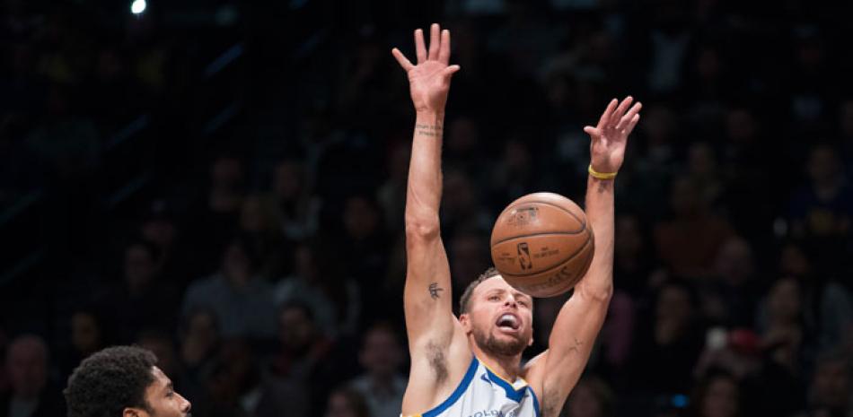 Stephen Curry, de los Warriors de Golden State, reacciona tras recibir una falta de Spencer Dinwiddie, de los Nets de Brooklyn, en acción del partido de anoche en el baloncesto de la NBA.