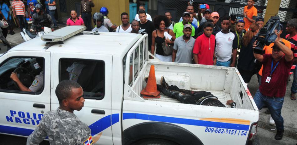 El hecho. Curiosos observan el cadáver del haitiano dentro de una camioneta de patrullaje de la Policía, en el sector Miraflores.