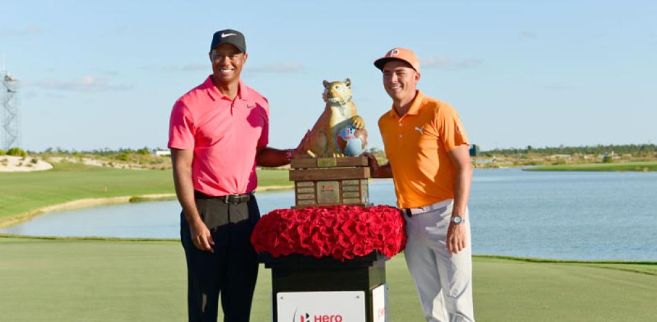 Rickie Fowler, a la derecha, posa con Tiger Woods y el trofeo luego de que Fowler ganar el torneo de golf “Hero World Challenge” en el Albany Golf Club en Nassau, Bahamas.