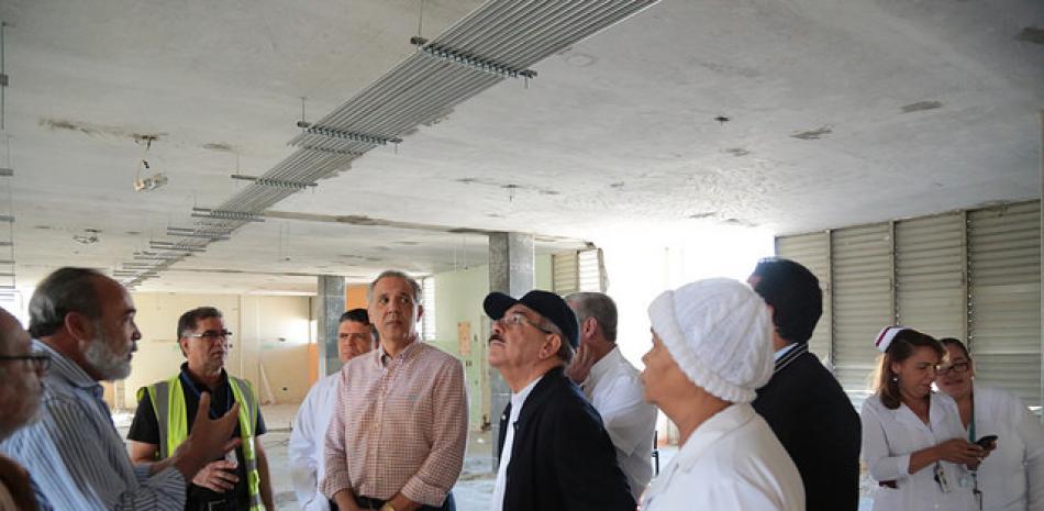 Visita. El presidente Danilo Medina junto a funcionarios y personal del hospital Arturo Grullón, cuando supervisaba ayer la marcha de la reconstrucción de ese centro de salud regional.
