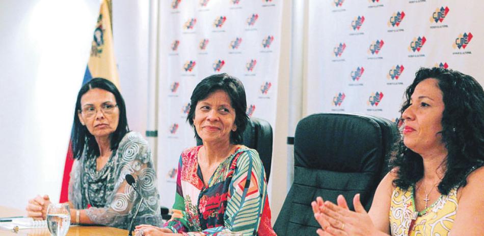 Informe. Las rectoras del Consejo Nacional Electoral (CNE), Socorro Hernández (i), Sandra Oblitas (c) y Tania D’Amelio (d), hablan durante el acto de entrega de informe de los observadores internacionales.