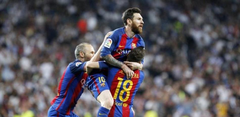 Lionel Messi brinca hacia los brazos de un compañero en el partido que el Barcelona venció al Real Madrid.