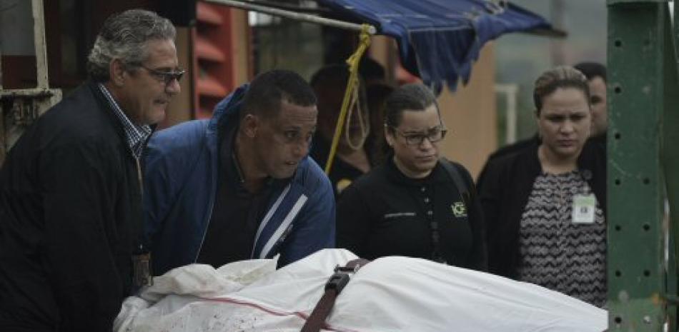 Médicos forenses retiran el cadáver de un individuo asesinado a tiros en San Juan.