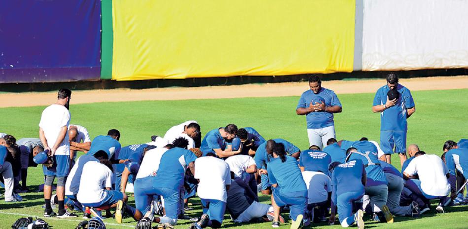 Jugadores y entrenadores de los Tigres del Licey comparten una oración al final de las prácticas ayer tarde en el estadio Quisqueya Juan Marichal.