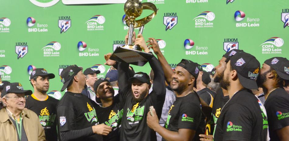 Juan Carlos Pérez, junto a varios compañeros, levanta con júbilo el trofeo de campeones, luego de vencer 11-4 al Licey en el Estadio Quiaqueya Juan Marichal.