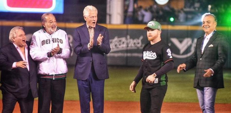 El expresidente de Estados Unidos, Bill Clinton, acompañado del empresario Carlos Slim, Carlos Bremer, y el presidente de la Liga Mexicana del Pacífico, Omar Canizales aplaude al campeón mundial Saúl -- Canelo-- Álvarez, luego que éste realizara el lanzamiento de honor previo al partido de segunda hora entre los Criollos de Caguas (Puerto Rico) y los Tomateros de Culiacán (México) para dejar formalmente inaugurada la Serie del Caribe, que se realizará hasta el día ocho en el Estadio Charros de Jalisco.