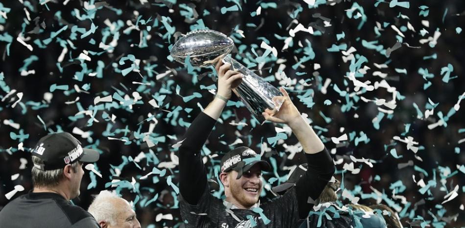 Carson Wentz, quarterback de los Eagles,  sostiene el trofeo de campeón de la NFL, despues de que el conjunto de Filadelfia ganara Super Bowl 52  de la NFL, congtra los New England Patriots, en Minneapolis. Los Eagles ganaron 41-33.