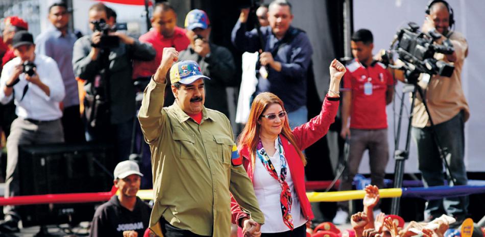 Crisis. El presidente venezolano, Nicolás Maduro, y la primera dama, Cilia Flores, saludan a seguidores durante una manifestación por el fallido golpe de Estado de 1992. La decisión del gobierno de seguir con las elecciones ha ampliado la crisis interna, dijeron analistas.