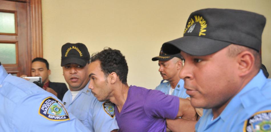 Autoridades policiales cuando conducían ayer al confeso asesino Víctor Portorreal Mendoza (Chamán) a una celda en San Pedro.