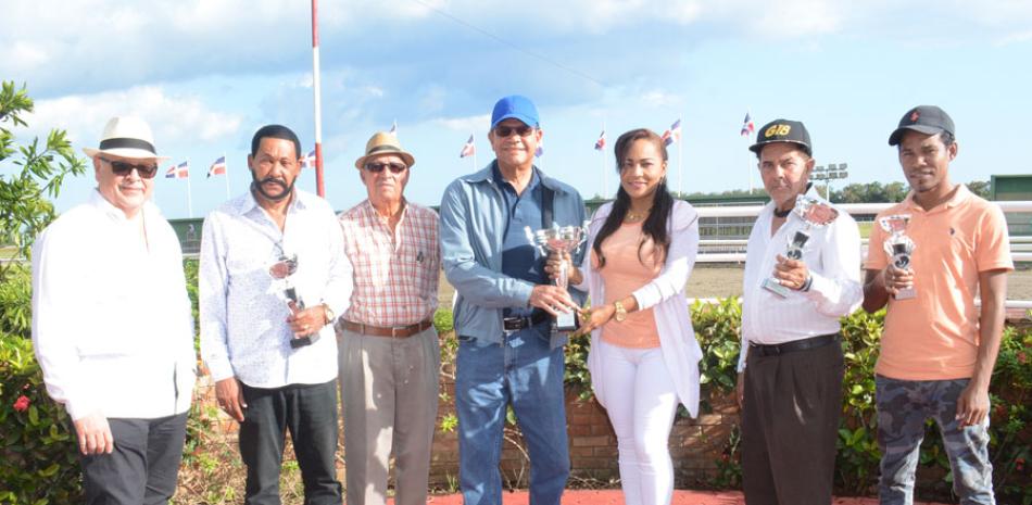 Carmen Betancourt entrega trofeo a Osiris Bautista, del establo Moisés y dueño del ejemplar Lighting Go, campeón de la edición del Clásico Día de San Valentín 2018.
