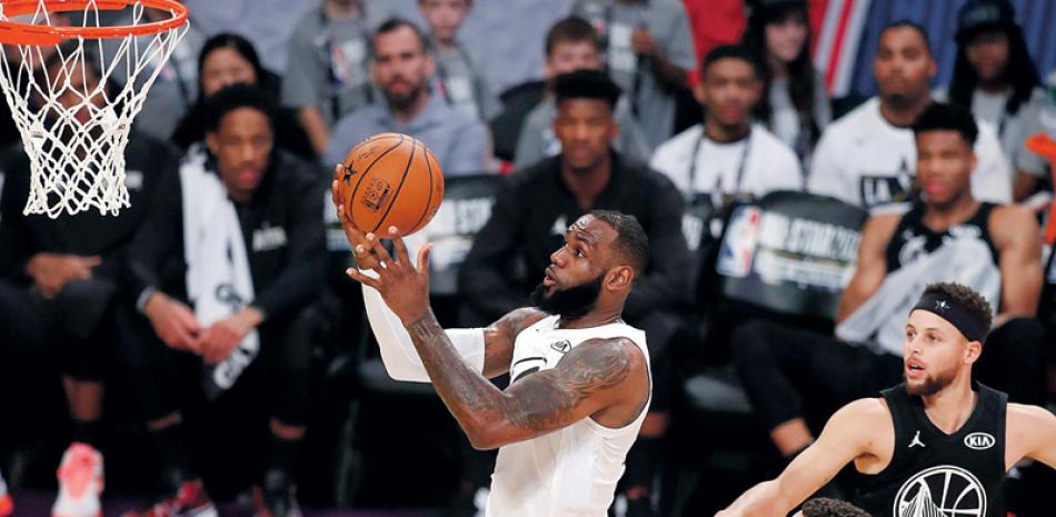 LeBron James penetra en busca de un canasto ante la mirada de Stephen Curry, Draymond Green y Klay Thompson durante el Partido de Estrellas de la NBA.