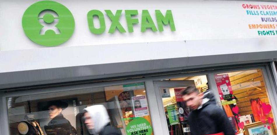 Daño colateral. Peatones pasan delante de una tienda Oxfam en Londres, Reino Unido, el 14 de febrero pasado. Oxfam Intermón en España ha recibido 1,200 peticiones de baja de socios, tras conocerse el escándalo sexual.