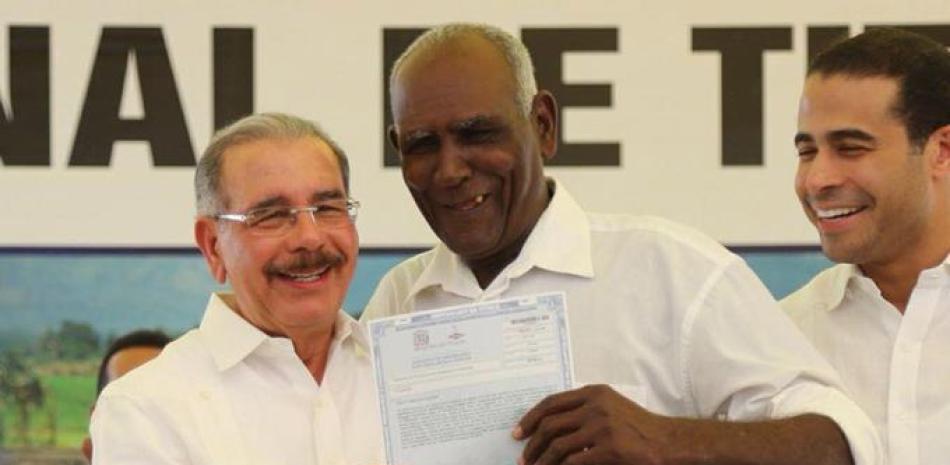 Asentamiento. El presidente Danilo Medina entrega el título definitivo a uno de los agricultores beneficiados.