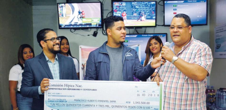 Francis Pimentel recibe de manos de Angelo Rodríguez, director de Comunicaciones del Hipódromo V Centenario, el cheque por más de 1.5 millones por haber ganado pool de 6 de Gustream Park.