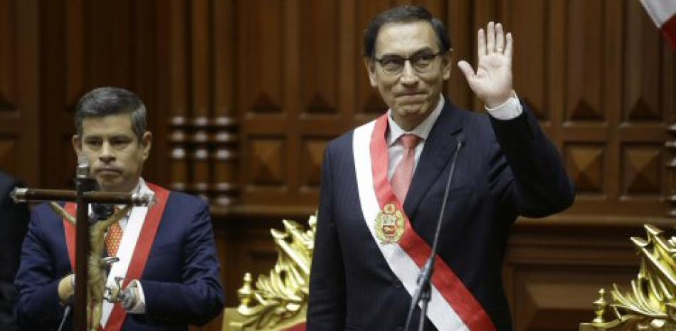 El recién juramentado presidente peruano Martín Vizcarra saluda flanqueado por el presidente del Congreso Nacional, Luis Galarreta, en Lima, el viernes 23 de marzo de 2018. (AP Foto / Martin Mejía).