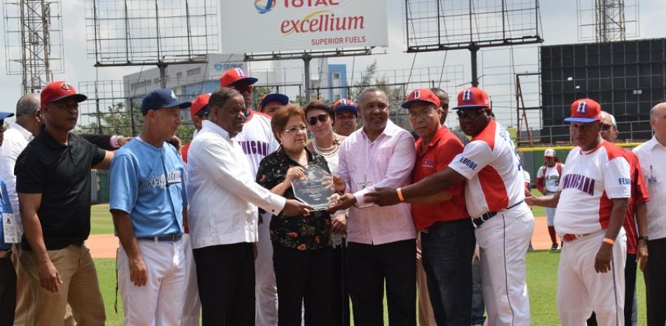 La doctora Alejandrina Germán al momento de una placa de reconocimiento de manos del Ministro de Deportes, Danilo Díaz y Juan Núñez, en el marco de la apertura del Pre Mundial de Béisbol Femenino.