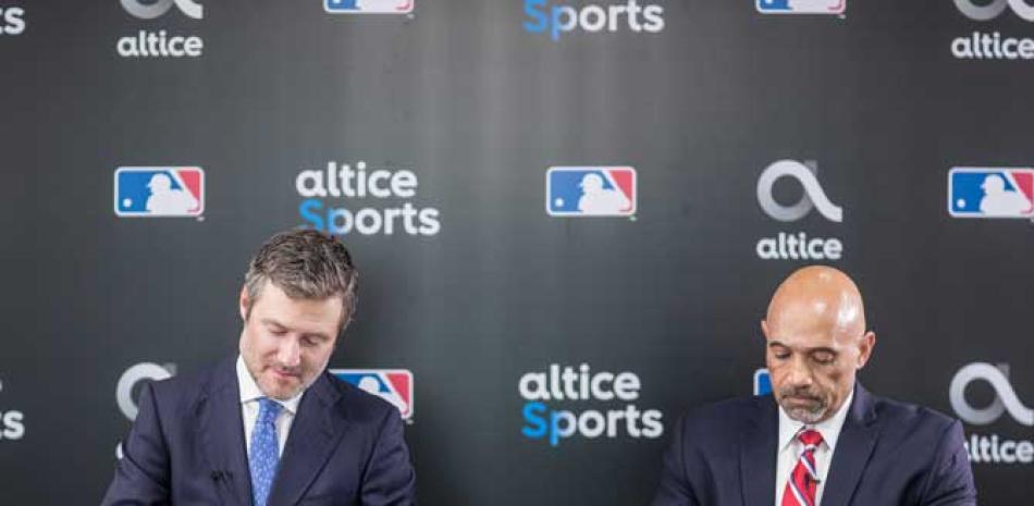 Martin Roos, CEO de Altice Dominicana (i) y Rafael Pérez, representante de MLB en el país (d) posan para las camaras al momento de la firma del acuerdo.