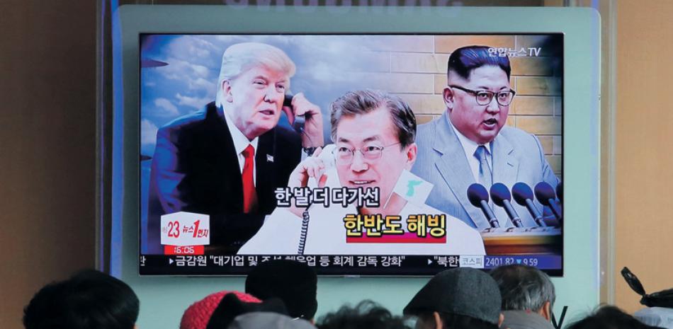 TV. La gente  observa una pantalla de television en una estación de trene sen Seúl, que muestra a Donald Trump y al líder norcoreano Kim Jong-Un, enlos extremos