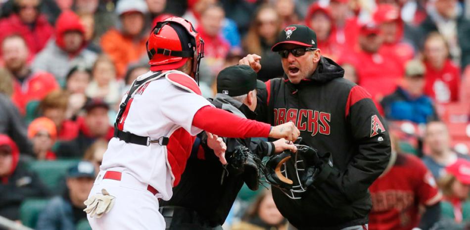 El manager de los Diamondbacks de Arizona, Torey Lovullo, discute con el receptor boricua de los Cardenales de San Luis, Yadier Molina, mientras se interpone el umpire Tim Timmons, durante el encuentro del domingo 8 de abril de 2018 (Chris Lee/St. Louis Post-Dispatch via AP)