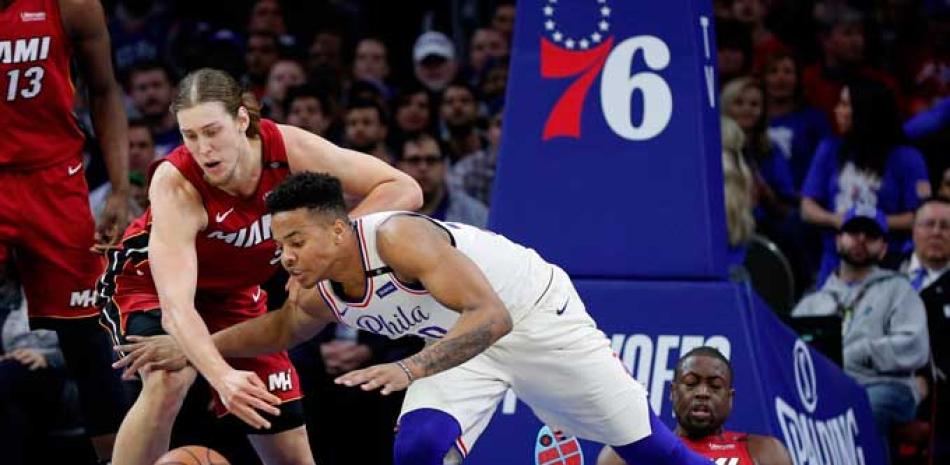 Kelly Olynyk, de Miami, y Markelle Fultz, de los Sixers, luchan por una bola perdida durante el partido de anoche en el baloncesto de la NBA.