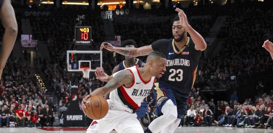 Anthony Davis, de los Pelicans, realiza una gestión defensiva ante el avance de Damian Lillard, de los Trail Blazers de Portland, en el partido de primera ronda de los playoffs de la NBA.