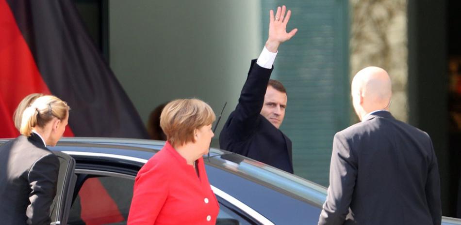 Saludo. El presidente francés, Emmanuel Macron, saluda a su llegada a la Cancillería para una reunión de trabajo con la canciller alemana, Angela Merkel, al centro, en Berlín.