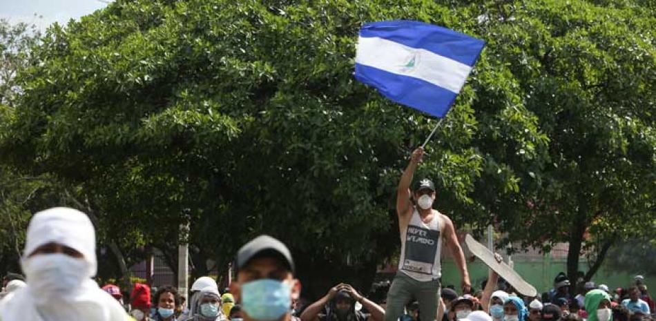 Quejas. Un manifestante ondea una bandera de Nicaragua durante una protesta ayer cerca de la Universidad Politécnica, en Managua.
