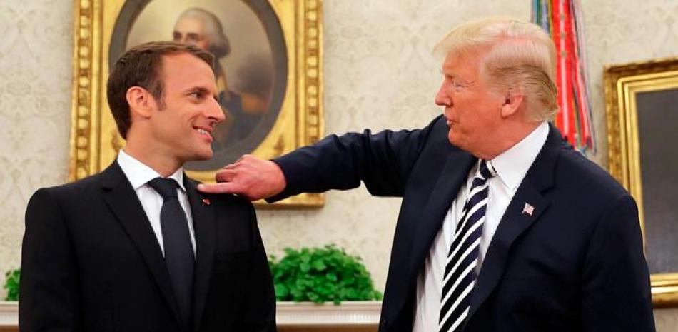 Gesto. Donald Trump, en la Oficina Oval, le quita la caspa a Emmanuel Macron.