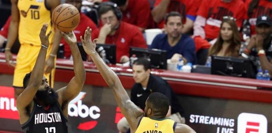 Derrick Favors, de los Jazz, trata de bloquear un intento al canasto de James Harden, de los Rockets, en el primer partido de la semifinal del Oeste en los playoffs de la NBA.