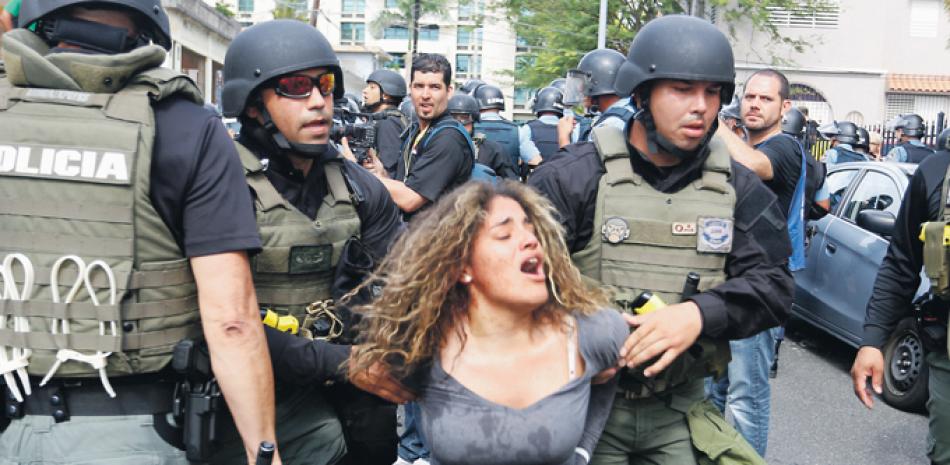 Represión. Agentes policiales arrestan a una manifestante ayer en San Juan de Puerto Rico, en el Día del Trabajo.