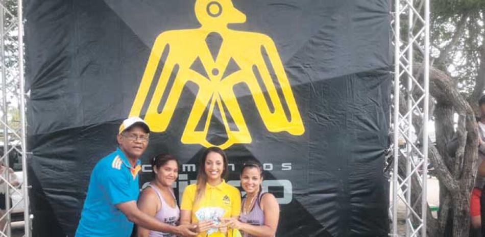 El presidente de FEVOSA, José Aybar, y Carolina Hernández, del departamento de Mercadeo de Cementos Cibao, premian a Las Menores de Sabaneta.