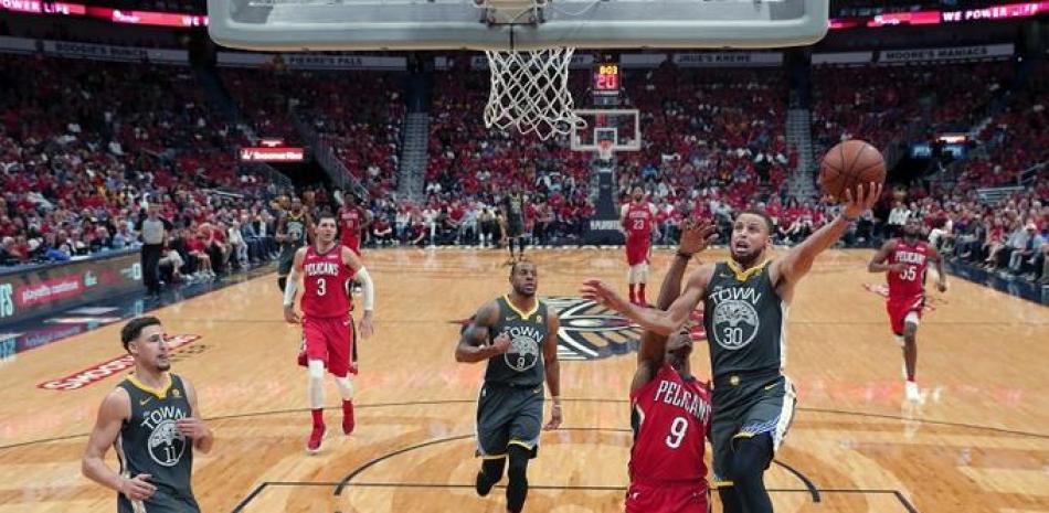 Stephen Curry, de los Warriors, intenta anotar un canasto sobre la defensa de Rajon Rondo, de los Pelicans, en acción del cuarto partido de la semifinal del Oeste de los playoffs de la NBA.