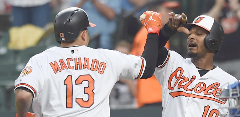 Adam Jones, de Baltimore, congratula a Manny Machado tras este conectar su décimo cuadrangular de la temporada en el partido de anoche contra los Reales de Kansas City.