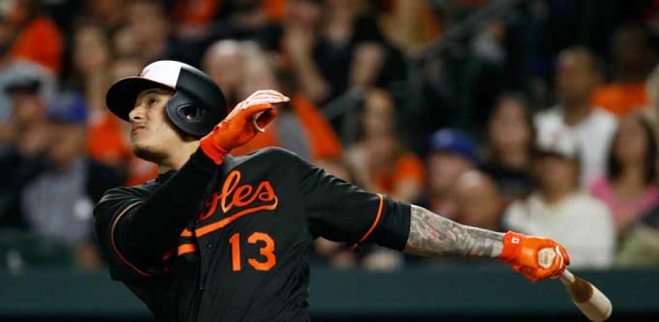 Manny Machado extiende sus brazos y observa la dirección de la pelota en el grand slam que produjo anoche y que definió el choque para los Orioles.