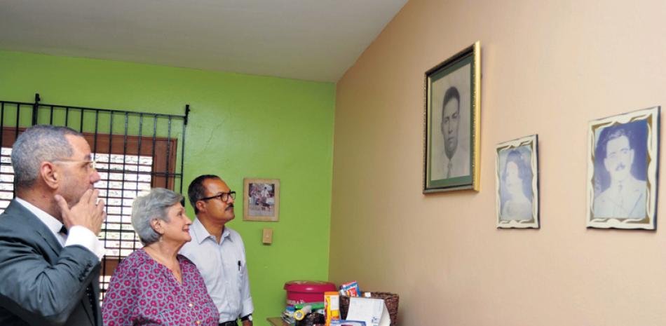 Nostalgia. María Leonor González junto a sus hijos, Húascar Antonio y Manuel Tomás Tejeda González, observan una foto de su padre y de otros familiares en su hogar.