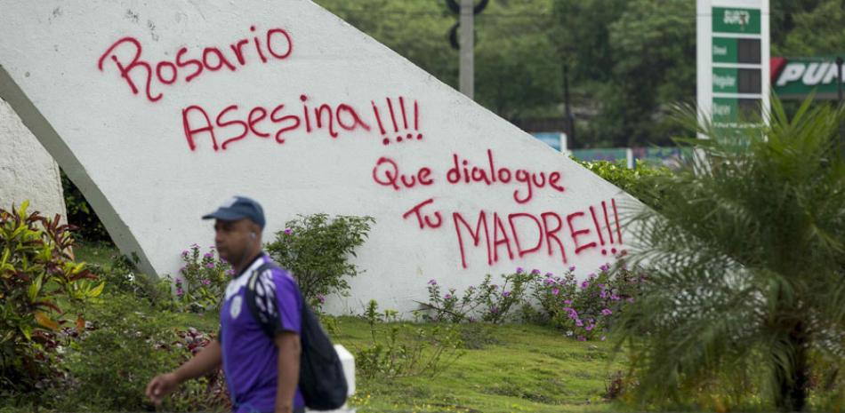Protesta. Un hombre camina frente a un monumento con un letrero en contra de la vicepresidenta de Nicaragua, Rosario Murillo.