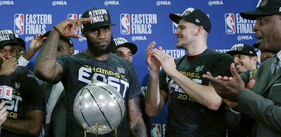 LeBron James hace un saludo durante la ceremonia de entrega de la cual, la está junto a él, mientars es aplaudido por varios de sus compañeros luego de que los Cavaliers vencieran a los Celtics
