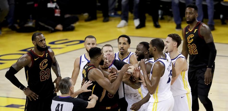 Jugadores de los Cavaliers y los Warriors son contenidos tras un conato de pleito entre Draymond Green y Tristan Thompson en los segundos finales del primer partido de la seriei final de la NBA.