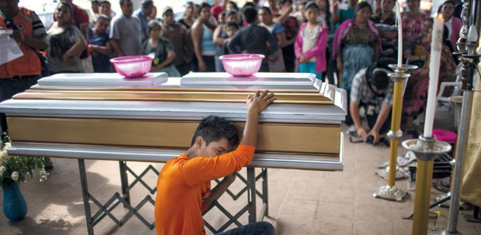 Dolor. Francisco Dávila llora la muerte de su madre, Maritza Nij Ramos Dávila, de 40 años, durante el funeral de la señora en Alotenago.
