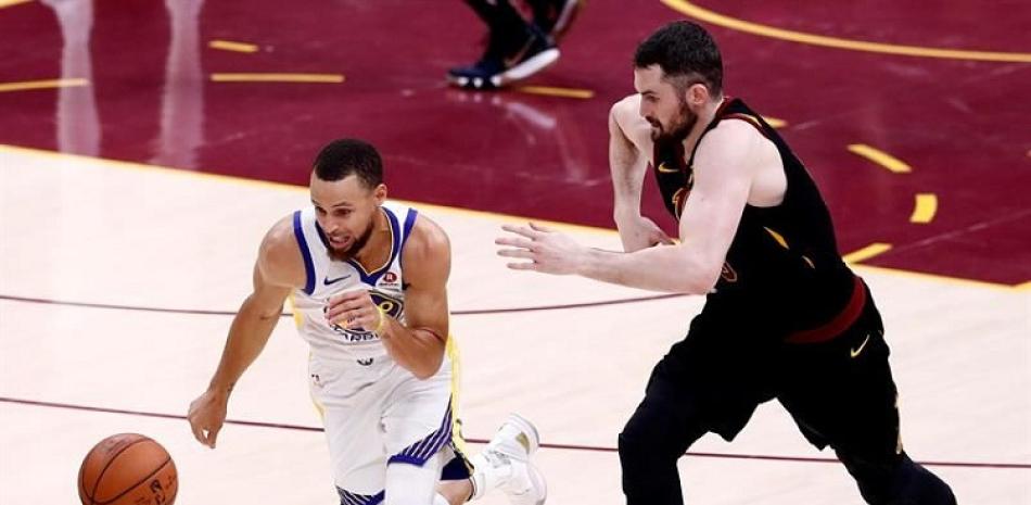 Stephen Curry, de los Warriors, maneja el balón ante la defensa de Kevin Love, de los Cavaliers, en el cuarto partido de la serie final de la NBA.