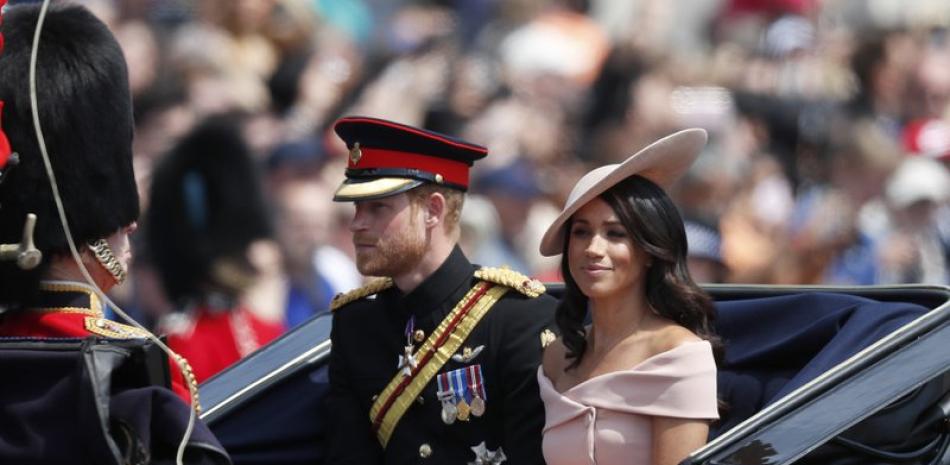 El príncipe Enrique de Inglaterra (izquierda) y Meghan Markle, duques de Sussex, en un carruaje durante el desfile anual del Trooping the Colour, para conmemorar el cumpleaños de la reina Isabel II, en Londres, el 9 de junio de 2018. (AP Foto/Frank Augstein).