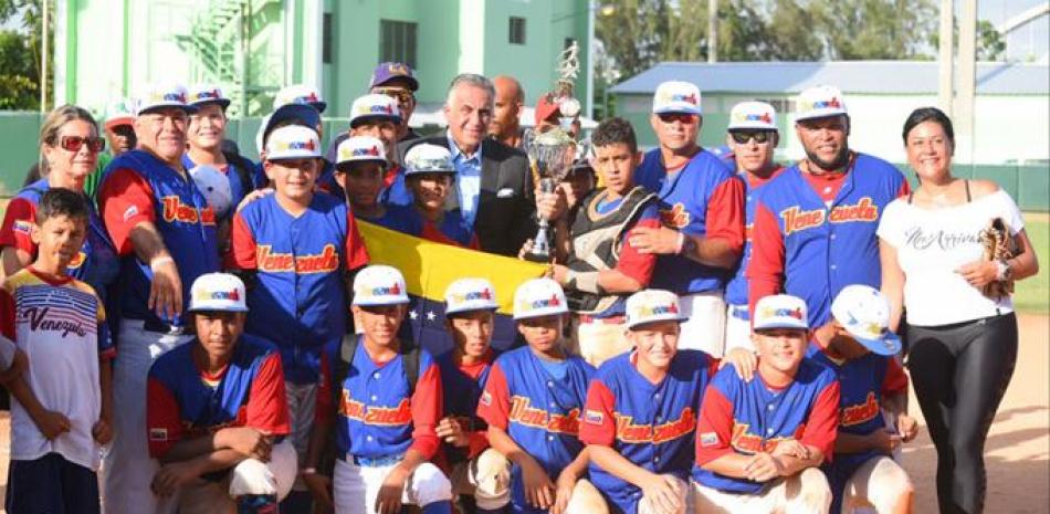 Luis Mejía, presidente del Comité Olímpico Dominicano, entrega el trofeo de campeón al equipo de Venezuela.