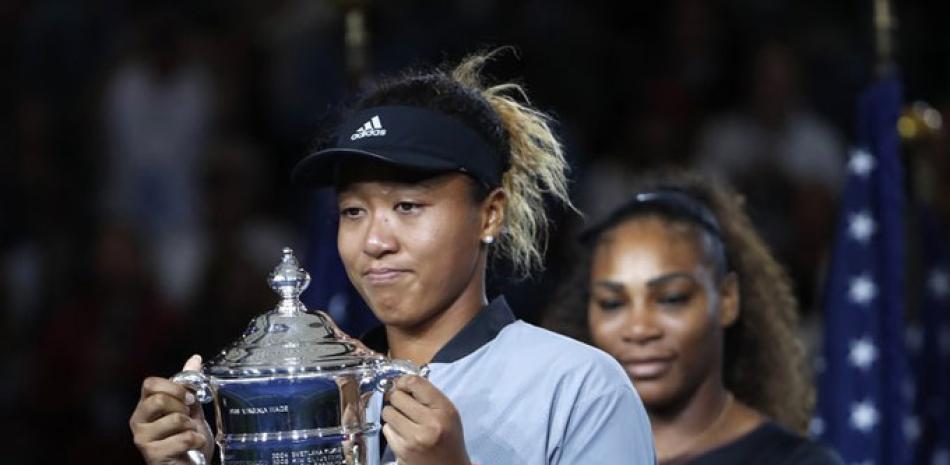 Naomi Osaka, de Japón, ostenta el trofeo después de derrotar este sábado a Serena Williams en la final femenina del torneo de tenis del US Open. (AP Photo)