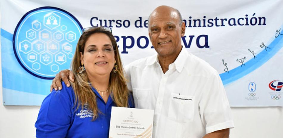 Luis Elpidio Cumba entrega un certificado de participación en el curso de Administración Deportiva a Elka Jiménez.