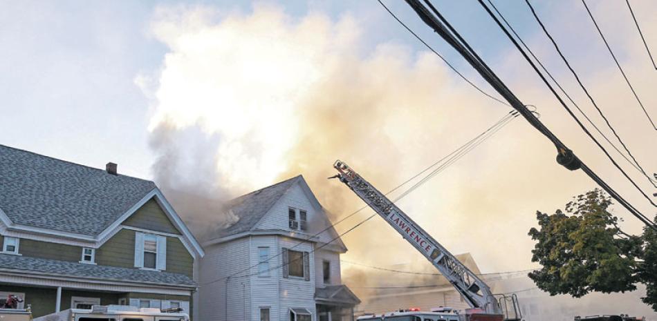 Promesas. Bomberos combaten un incendio en Lawrence, Massachusetts, ayer, luego de una serie de explosiones de gas reportadas en ciudades al norte de Boston incendiaran casas y forzaron la evacuación obligatoria de los residentes.