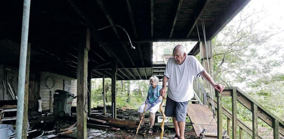 Daño. Elton y Claudia Matheson observan los daños a su vivienda luego del paso de Florence por la Isla Emerald, en Carolina del Norte, ayer.