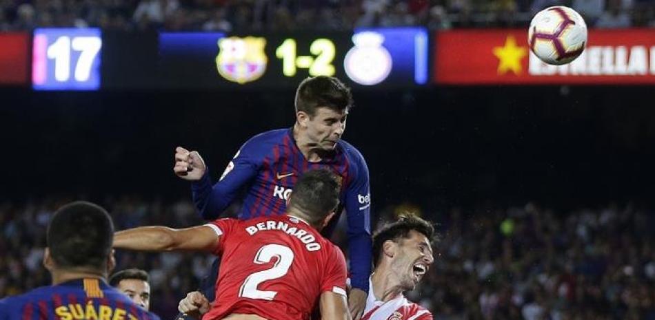 Gerard Piqué, del Barcelona, cabecea el balón para anotar el gol del empate en el partido entre Barcelona y Girona.