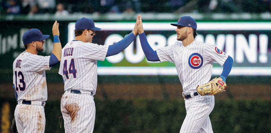 Júbilo. Anthony Rizzo, al centro, celebra con Kris Bryant (derecha) luego que los Cubs derrotaran a los Cardinales.